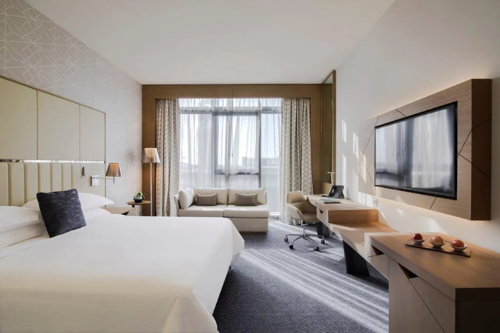 Großes Hotelzimmer mit Bett und Fernseher